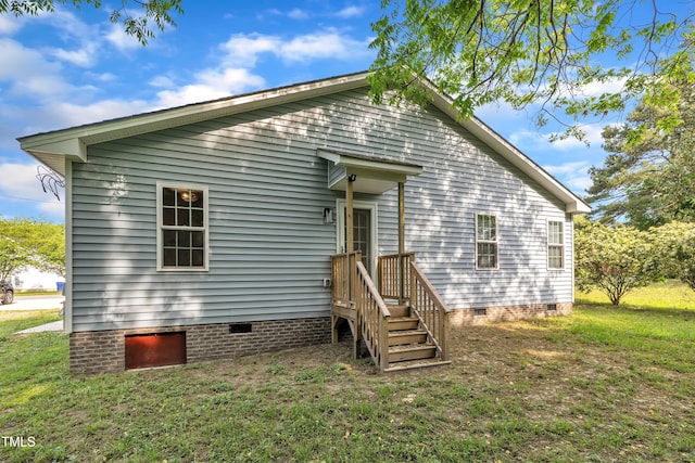 rear view of property featuring a yard and crawl space