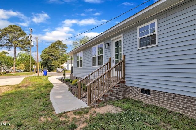 view of exterior entry with a yard and crawl space