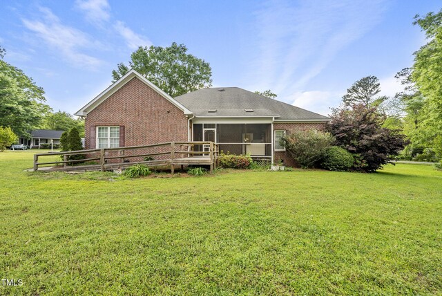 406 N Wakefield St, Zebulon, NC 27597 - back of property with brick siding, a sunroom, and a lawn