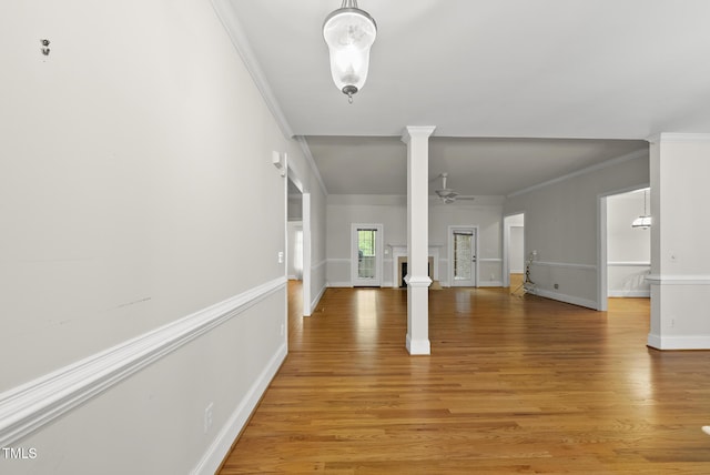 406 N Wakefield St, Zebulon, NC 27597 - unfurnished living room with ornate columns, crown molding, light wood-style flooring, baseboards, and ceiling fan
