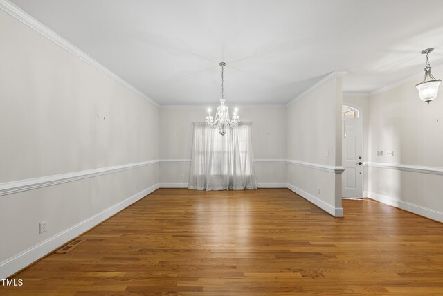 406 N Wakefield St, Zebulon, NC 27597 - unfurnished dining area with a chandelier, wood finished floors, crown molding, and baseboards