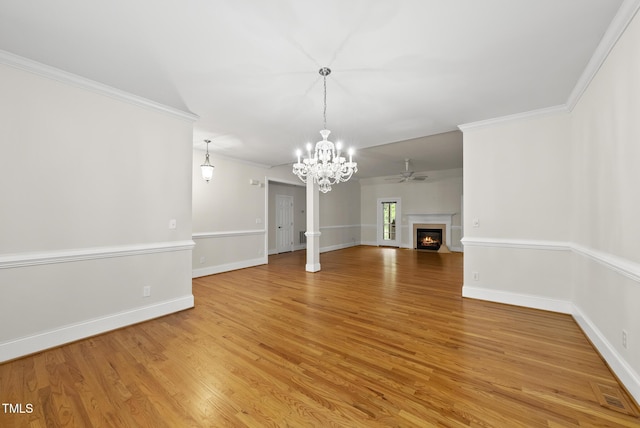 406 N Wakefield St, Zebulon, NC 27597 - unfurnished living room with a chandelier, light wood-style flooring, a warm lit fireplace, ornamental molding, and baseboards