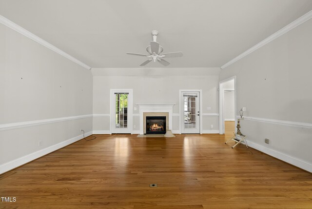 406 N Wakefield St, Zebulon, NC 27597 - unfurnished living room with ceiling fan, wood finished floors, a fireplace with flush hearth, ornamental molding, and baseboards