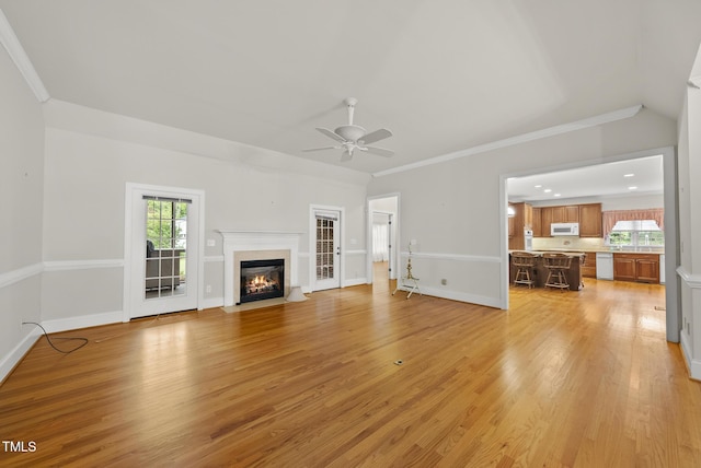 406 N Wakefield St, Zebulon, NC 27597 - unfurnished living room featuring a ceiling fan, light wood-style flooring, a fireplace with flush hearth, baseboards, and ornamental molding