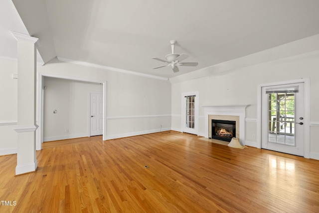 406 N Wakefield St, Zebulon, NC 27597 - unfurnished living room with a ceiling fan, light wood-type flooring, a fireplace with flush hearth, ornate columns, and baseboards