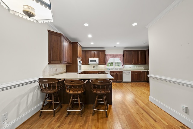 406 N Wakefield St, Zebulon, NC 27597 - kitchen with white appliances, light countertops, tasteful backsplash, light wood-type flooring, and recessed lighting