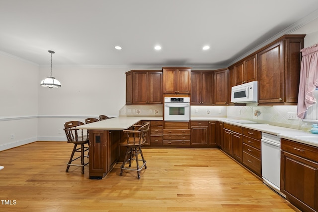 406 N Wakefield St, Zebulon, NC 27597 - kitchen with white appliances, a kitchen breakfast bar, light countertops, backsplash, and crown molding