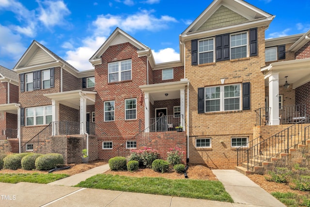 townhome / multi-family property featuring stairs and brick siding