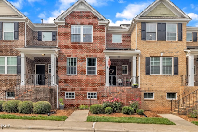 townhome / multi-family property with brick siding and stairs