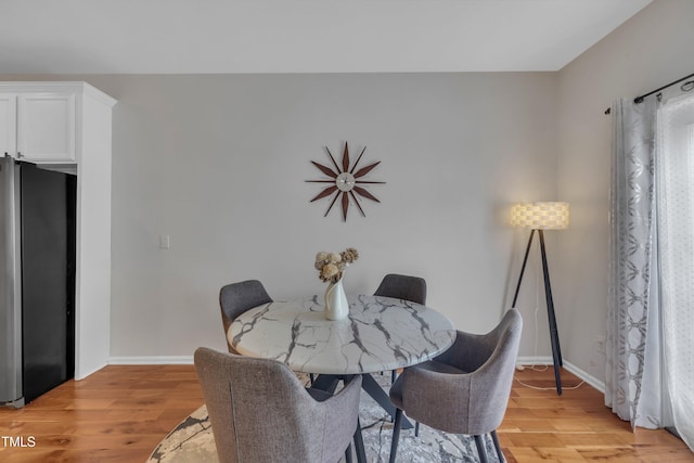 dining room with light wood-style flooring and baseboards