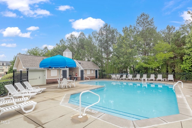 community pool with fence and a patio