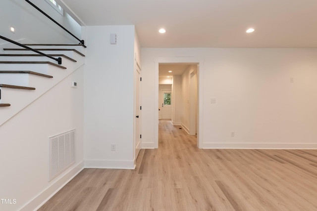corridor with light wood-style floors, baseboards, recessed lighting, and stairs