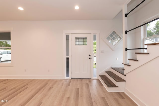 foyer with light wood-type flooring, stairway, baseboards, and recessed lighting