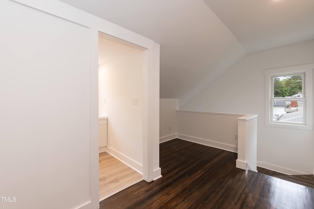 bonus room with vaulted ceiling, dark wood finished floors, and baseboards