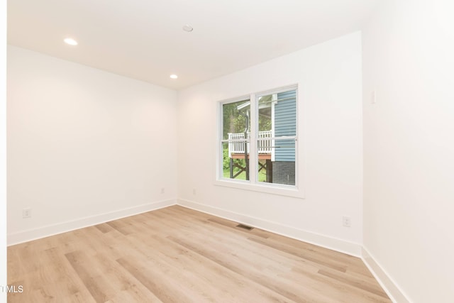spare room with light wood finished floors, baseboards, and recessed lighting