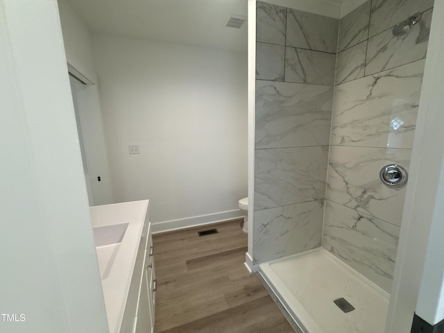 full bath featuring a shower stall, wood finished floors, toilet, and vanity