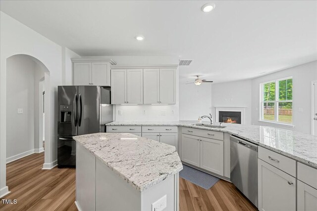 1005 Whispering Creek Ct, Knightdale, NC 27545 - kitchen with stainless steel dishwasher, arched walkways, visible vents, ceiling fan, and refrigerator with ice dispenser