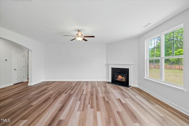1005 Whispering Creek Ct, Knightdale, NC 27545 - unfurnished living room with a fireplace with flush hearth, ceiling fan, light wood-style flooring, baseboards, and visible vents