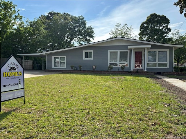 ranch-style house with driveway, a front lawn, and an attached carport