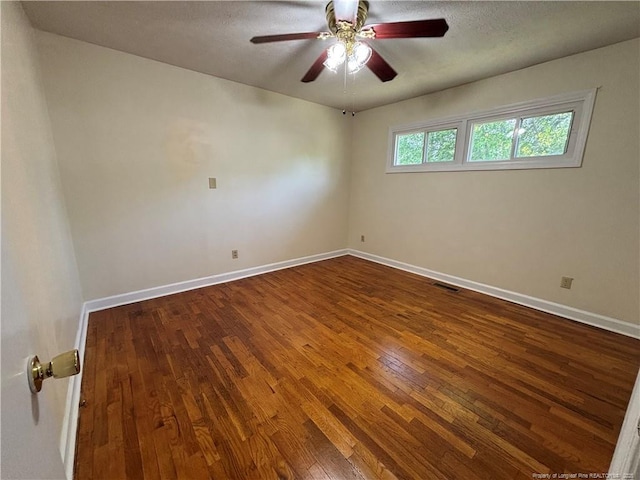 unfurnished room featuring baseboards, visible vents, hardwood / wood-style flooring, and ceiling fan