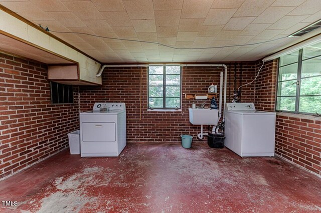 basement with independent washer and dryer, brick wall, visible vents, and a sink