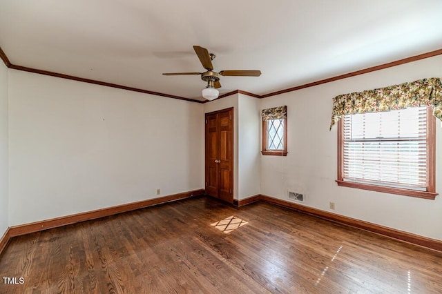 unfurnished room featuring a ceiling fan, dark wood-style flooring, visible vents, crown molding, and baseboards