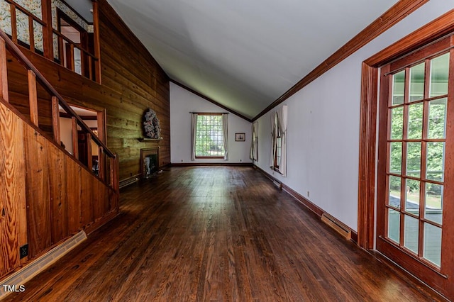 unfurnished living room with crown molding, a fireplace, vaulted ceiling, dark wood finished floors, and stairs