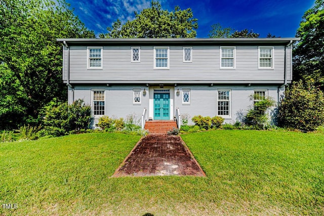 colonial-style house featuring french doors, brick siding, and a front yard