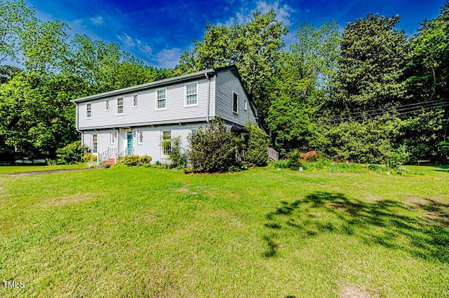 colonial home featuring a front yard and entry steps