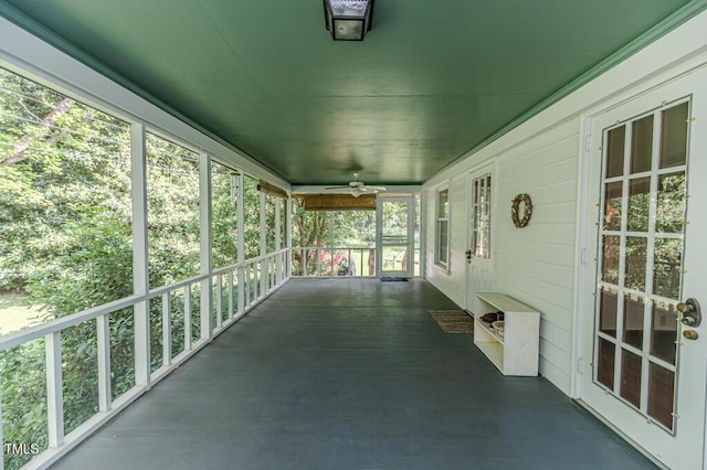 unfurnished sunroom featuring ceiling fan