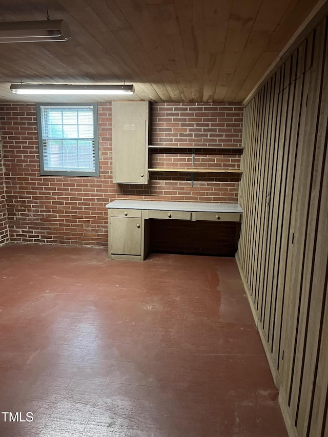 below grade area featuring brick wall and wood ceiling