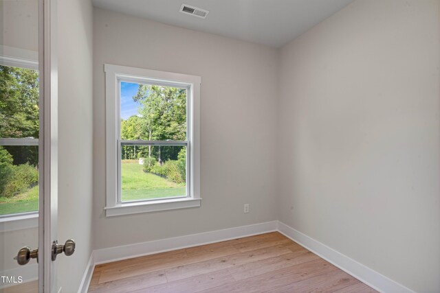 spare room with visible vents, light wood-style flooring, baseboards, and a healthy amount of sunlight
