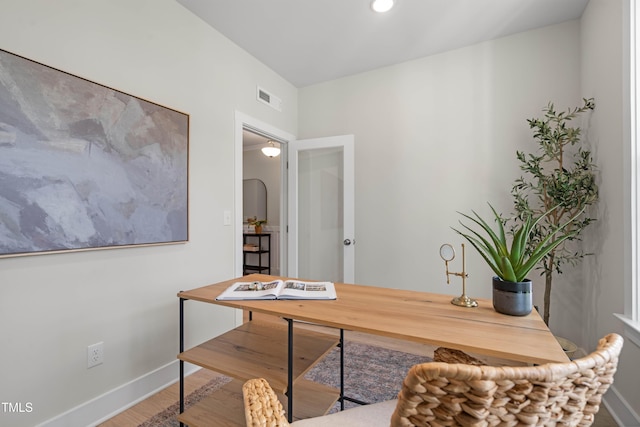 office area with baseboards, wood finished floors, and visible vents