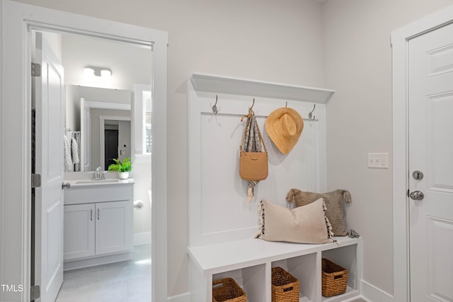 mudroom featuring baseboards and a sink