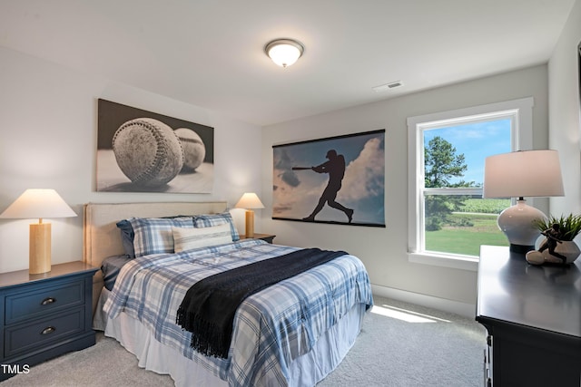 bedroom featuring baseboards, visible vents, and light colored carpet