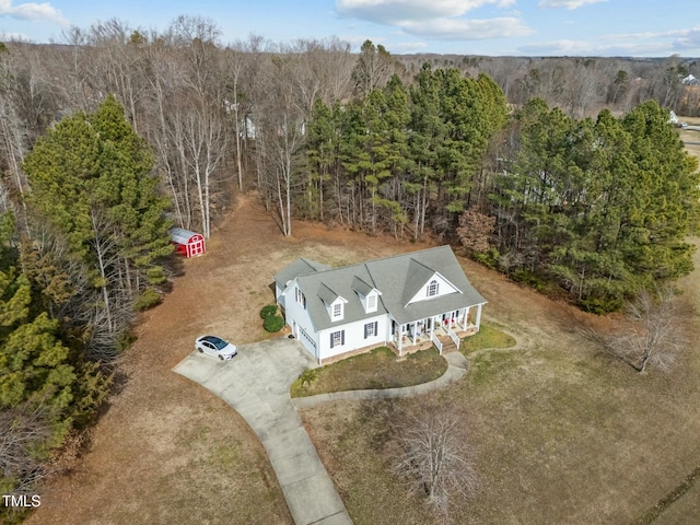 birds eye view of property featuring a wooded view