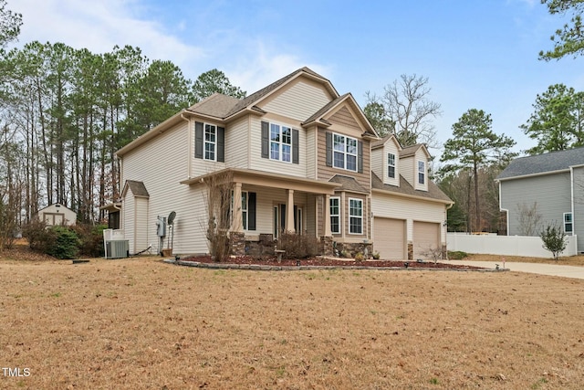 craftsman inspired home with fence, a garage, covered porch, central AC unit, and a shingled roof