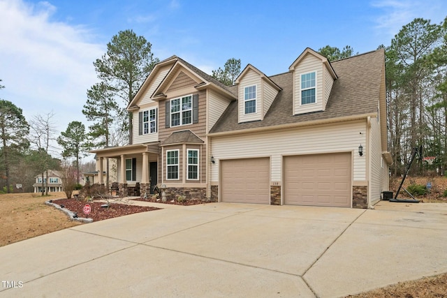 view of front of property with stone siding, driveway, an attached garage, and a shingled roof