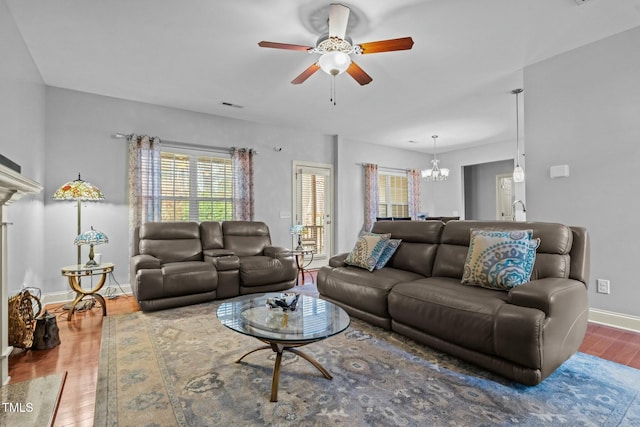 living room with wood finished floors, a chandelier, a ceiling fan, and baseboards