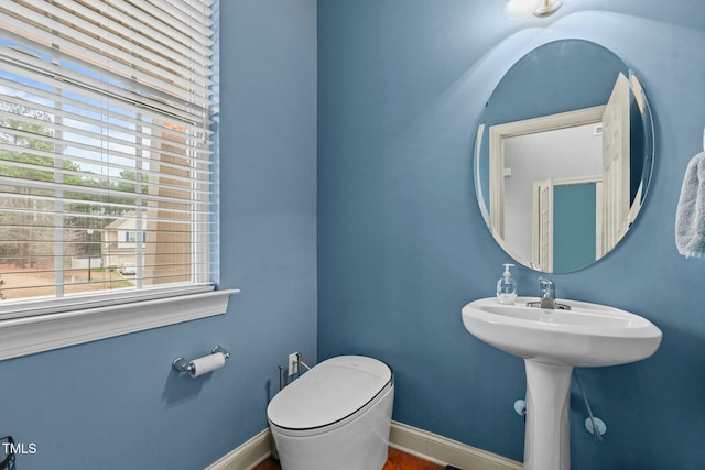 bathroom featuring toilet, wood finished floors, and baseboards