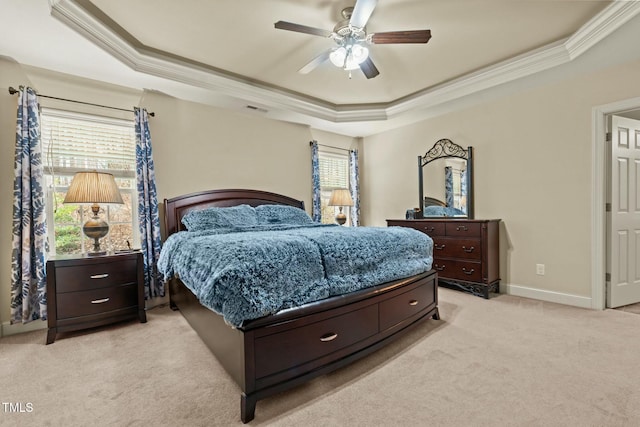 bedroom featuring a tray ceiling, light carpet, ornamental molding, ceiling fan, and baseboards