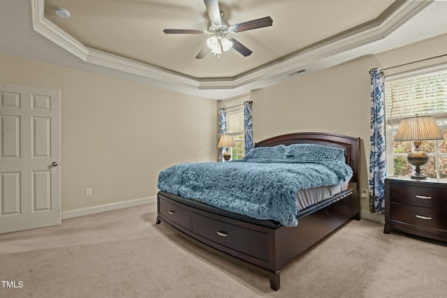 bedroom with a raised ceiling, light carpet, multiple windows, and ornamental molding