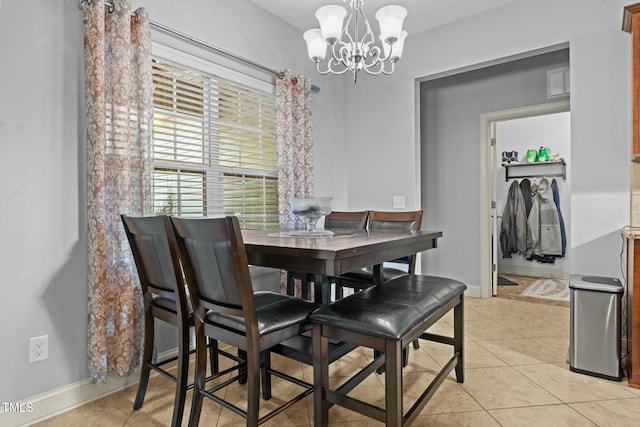 dining area featuring a chandelier, light tile patterned flooring, and baseboards
