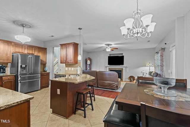 kitchen with stainless steel fridge with ice dispenser, a sink, a chandelier, a ceiling fan, and backsplash
