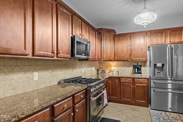 kitchen with stainless steel appliances, dark stone counters, light tile patterned floors, and decorative backsplash