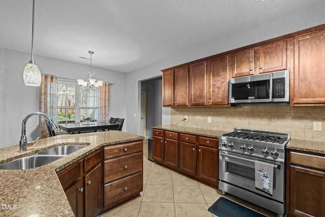 kitchen featuring stainless steel appliances, a sink, backsplash, a chandelier, and light tile patterned floors