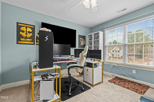 carpeted office space featuring a ceiling fan and baseboards