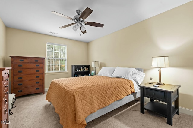 bedroom featuring light carpet, baseboards, and a ceiling fan