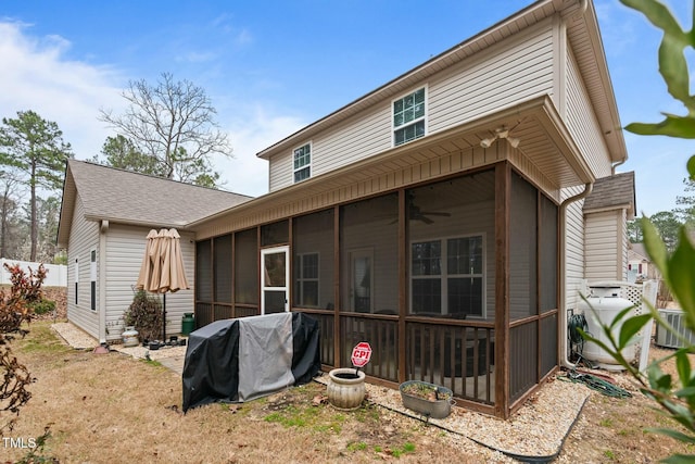 rear view of property featuring a sunroom, a ceiling fan, and roof with shingles