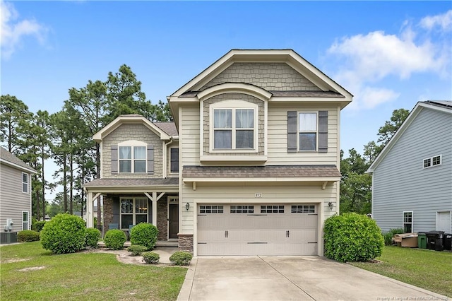 craftsman-style house featuring concrete driveway, stone siding, a front yard, and an attached garage